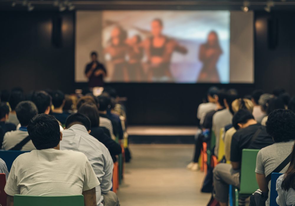 Rear view of Asian audience joining and listening speaker talking on the stage in the seminar meeting room or conference hall, education and workshop, associate and startup business concept